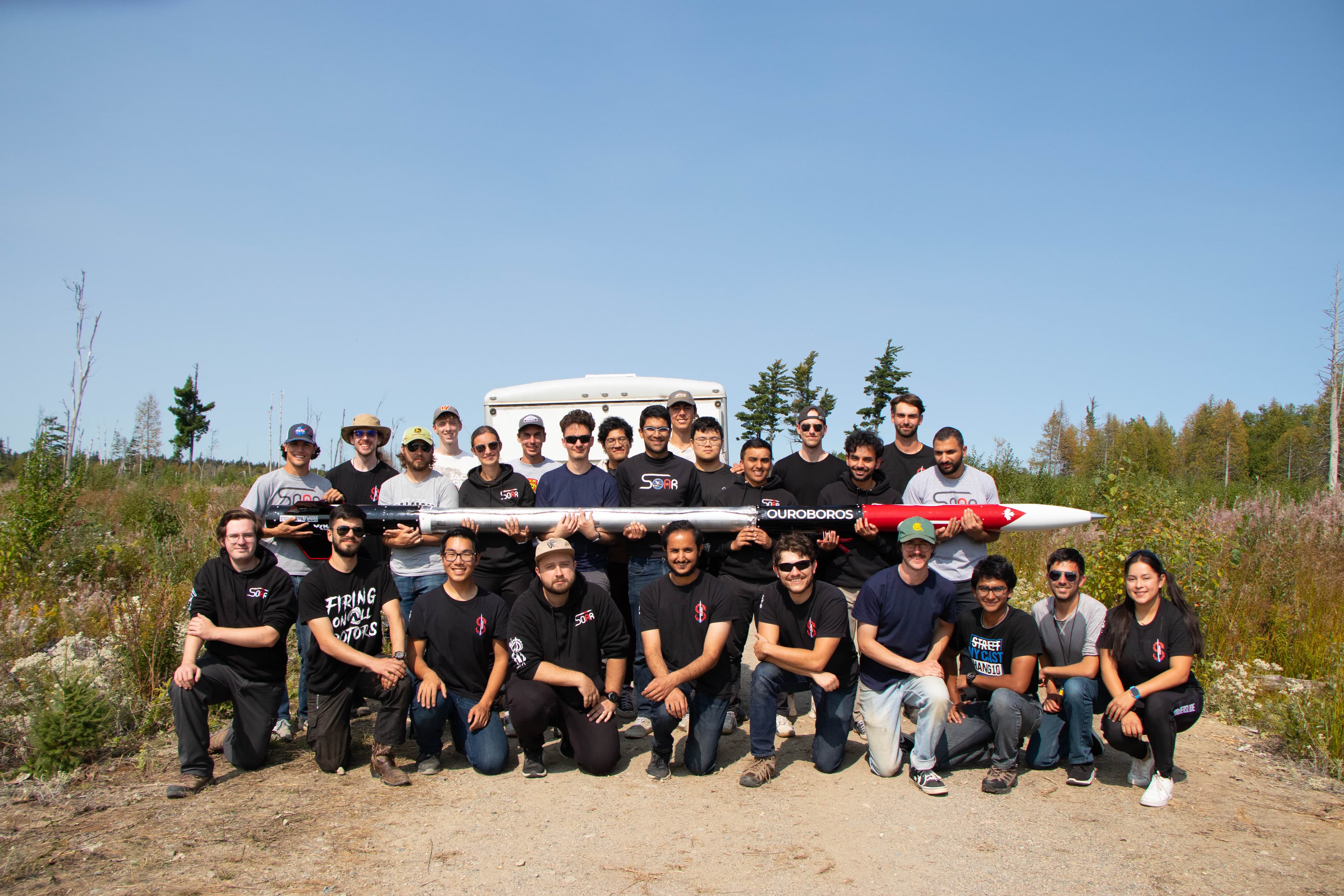 SOAR team standing with the Ouroboros rocket